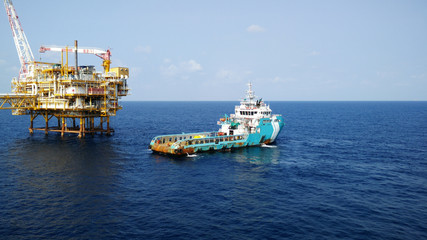 Supply boat transfer cargo to oil and gas industry and moving cargo from the boat to the platform. Boat is waiting transfer cargo and crews to platform. Supply boat support oil and gas industry.