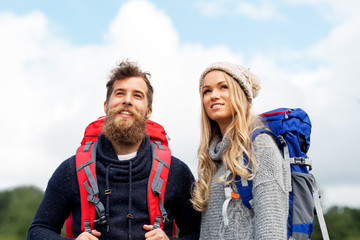 travel, tourism, hiking and people concept - couple of travelers with backpacks outdoors