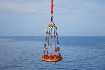 Personal basket use in offshore oil and gas lifting by crane operator for transfer passenger between boat and platform. © chanjaok1