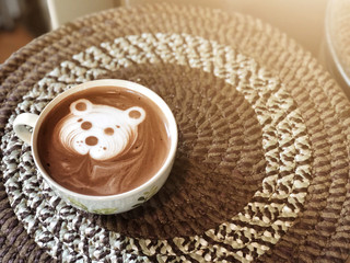 Cute bear face latte art Cocoa in white cup on paper box table ; cute latte art in your cup , love eat love coffee