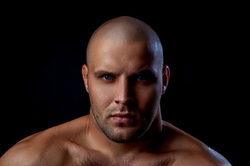 serious  young bald man standing isolated on a black background and looking at camera.Portrait Handsome man with confident face in studio