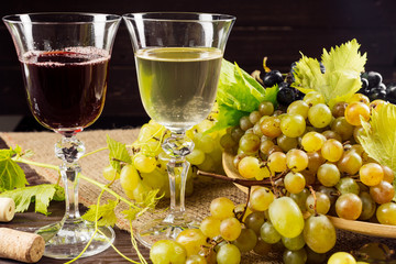 wine glass and bunch of grapes on wooden table