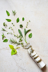 Ayurvedic herbal salt in glass jar. Sea salt with aromatic herb - rosemary, oregano, sage, marjoram, basil, thyme, mint, bay leaf. Copy space