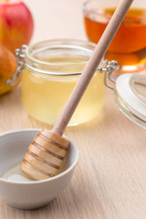Jewish holiday Rosh Hashanah background with honey and apples on wooden table.