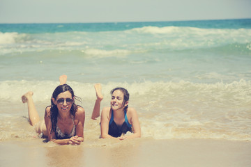 Mother and daughter having fun to spend time together on the beach at sunset