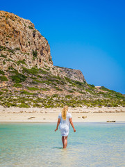 Crete, Greece: Blonde beautyful girl enjoying the beautiful crystal clear sea of Balos lagoon. Lagoon of Balos is one of the most visited tourist destinations on west coast of Crete.