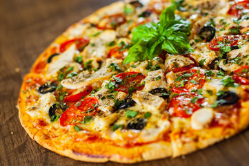 sliced Pizza with Chicken meat, Mozzarella cheese, tomato, olive. Italian pizza on wooden background