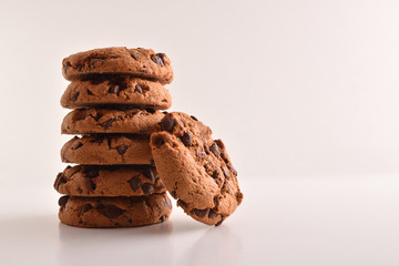Stack of cookies with chocolate on table and white background