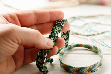 Hand holding woven friendship bracelet, closeup shot