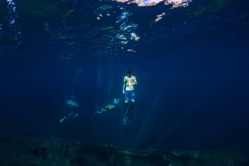 Fototapeta na wymiar Freediver man in the depth pop up and make shaka