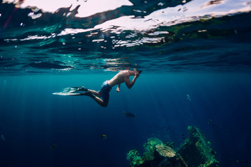 Freediver swim in the sea at USS Liberty Wreck, Bali - obrazy, fototapety, plakaty