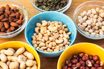 Assortment of mixed nuts on wood table background 