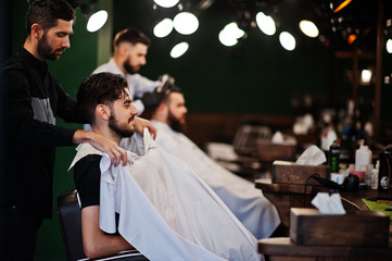 Handsome bearded man at the barbershop, barber at work.