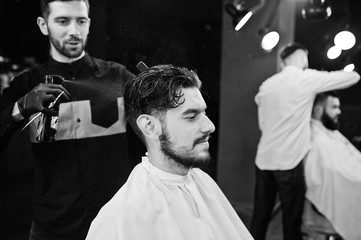 Handsome bearded man at the barbershop, barber at work.