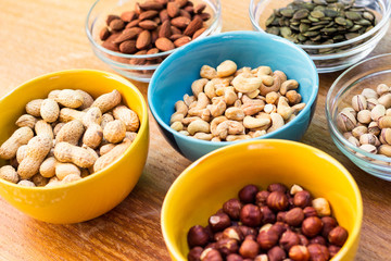 Assortment of mixed nuts on wood table background 