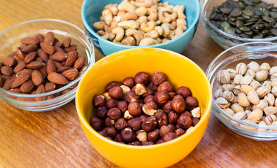 Assortment of mixed nuts on wood table background 