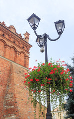 Decorated with flowers street lamp next to town hall on Old Town Square in Sandomierz, Poland