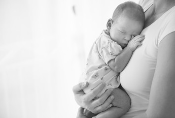 Newborn baby sleeping at mother breasts