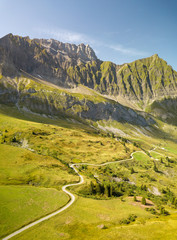 Road going toward a mountain in the french alps near the Col des Aravis.