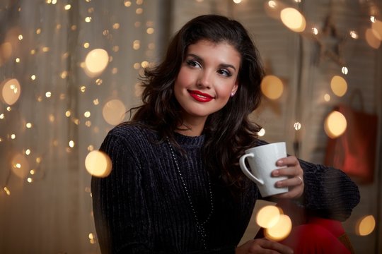 Young woman at home with hot drink in winter
