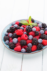 Fresh raspberries in a plate on a  vintage background.
