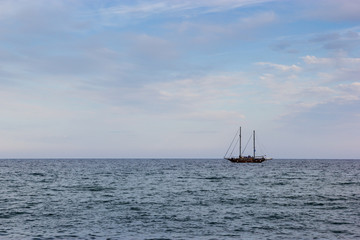 Fototapeta premium A black yacht boat in the sea with cloudy sky