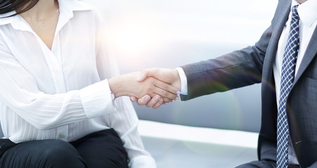 handshake of manager and client sitting in the office lobby.