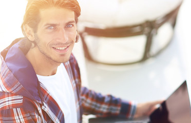 young man working on laptop and looking at camera. view from above