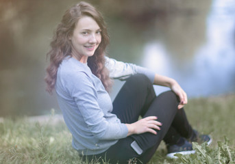 Naklejka na ściany i meble young woman sitting near the river