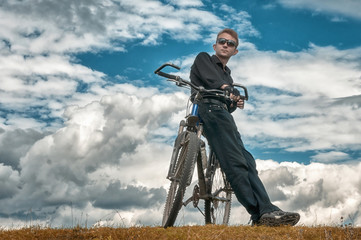 Man stay with bicycle in nature blue sky