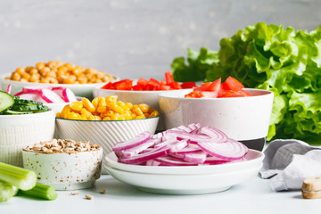 Assortment ingredients for healthy vegetarian salad in different portion bowls on a table. The concept of fitness and vegan food.