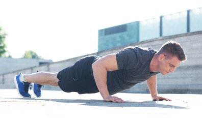 Young and sporty man training outdoor in sportswear. Sport, health, athletics.