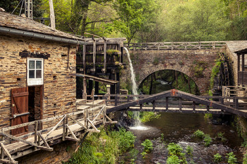 Fototapeta na wymiar Old, idyllic watermill in the mountains, surrounded by lush foliage (Taramundi, Spain)
