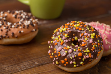 multicolored Donuts on wooden background. sweets for breakfast