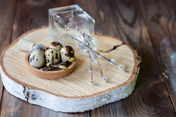 Decorative hand-painted Easter eggs in a nest on a wooden table. willow branches with blossoms. easter themed. Happy Easter.