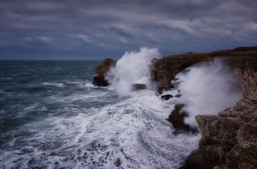 Dramatic nature background - big waves and dark rock in stormy sea, stormy weather. Dramatic scene....