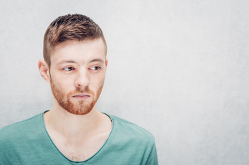 Portrait of a sad young man on gray background