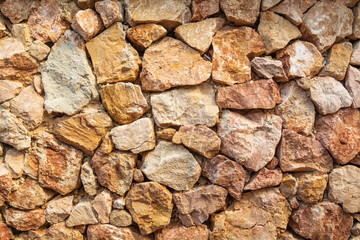 The wall is made of natural stone.