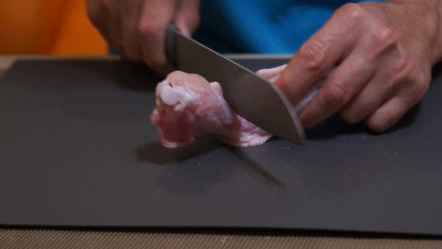 Chicken wings. Chef cooking wings. Man hands cuts chicken. Buffalo