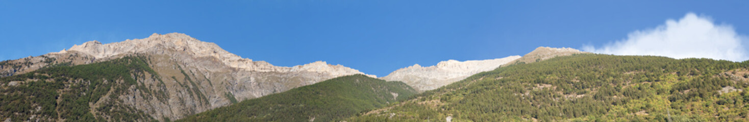 Fototapeta na wymiar Alps. Alpine panorama near Salbertrand, on the France Italy border. Mountain peaks in early morning sunshine.