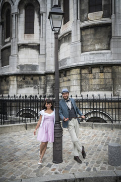 Amoureux dans la rue à Montmartre posant contre un lampadaire, Paris, France
