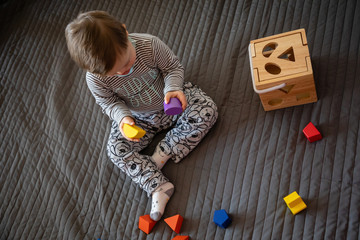 Naklejka premium Portrait of cute boy with Down syndrome playing in home living room