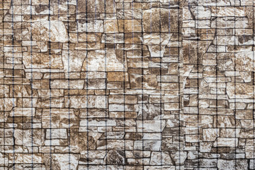 Background and texture of a fragment of a new built brown stone wall with copy space for writing text