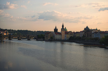 Fototapeta premium Picturesque view of the historical part of the city Prague during sunrise. Medieval Charles Bridge over Vltava River. Famous touristic place and travel destination in Europe. Prague, Czech Republic