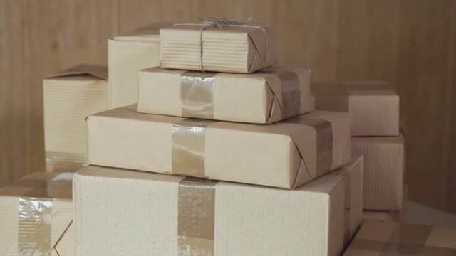A stack of large and small postal parcels on the table. Rotation