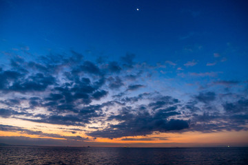 Fototapeta na wymiar 夜明けの海、空に月