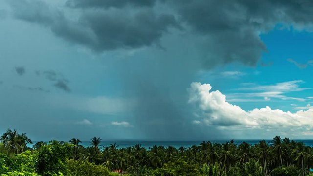 Rain and clouds in blue sky over sea and jungle in summer day. 4k time lapse