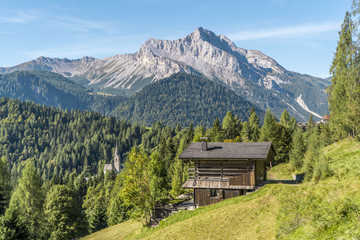 Fototapeta na wymiar Wooden house in the mountains, italian dolomites, Sauris