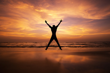 Silhouette of a man Jumping in the air on a beach