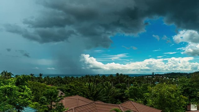 Rain and clouds in blue sky over sea,  jungle and rooftops in summer day. 4k time lapse